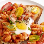 Gebackenes Spiegelei mit Bohnen und Tomaten auf Toast