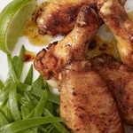 Hähnchenflügel in Honigsauce mit jungen Erbsen