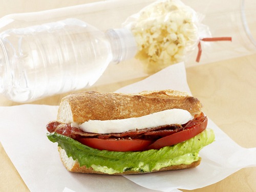 Come preparare un panino con mozzarella, pomodoro, lattuga romana e pesto.