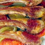Lammkotelett auf einem Bett aus würzigen Tomaten und Zwiebeln