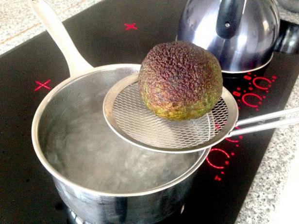 Die Avocado 10 Sekunden lang in kochendes Wasser geben.