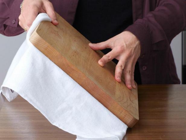 أمسك لوح التقطيع، ثم اقلبه مع صينية الخبز.
