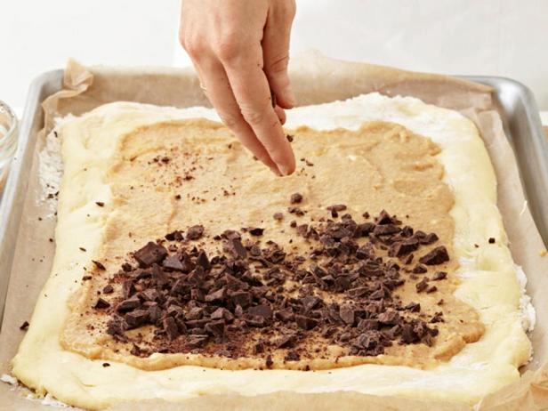 Den Teig mit der Mandelcreme bestreichen und mit Schokolade bestreuen.