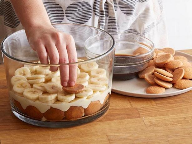 Schichten Sie abwechselnd Pudding und Bananen auf die Kekse.