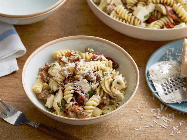Wie man Fusilli mit Wurst, Artischocken und sonnengetrockneten Tomaten zubereitet