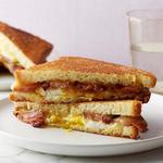 Warmes Sandwich mit Käse, Speck, Ei und Ahornsirup