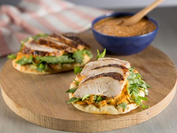 Würzige Hähnchenbrust auf geröstetem Fladenbrot mit weißem Bohnenhummus und Rucolasalat