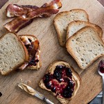 Ein Sandwich mit Erdnussbutter, Marmelade, gebratenem Speck und Beeren