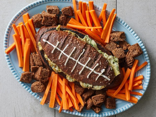 Artischocken-Spinat-Dip in einem fußballförmigen Brottopf
