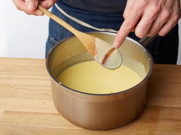 Zuerst die Vanillecreme zubereiten und die Konsistenz mit einem Holzlöffel prüfen.