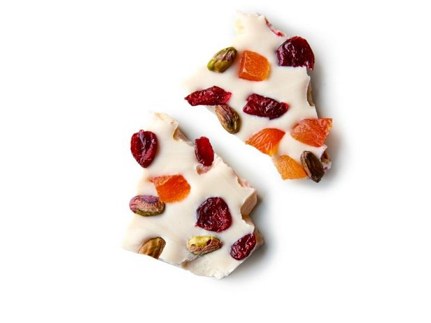 Weiße Schokoladentafel mit ganzen Pistazien, getrockneten Cranberries und getrockneten Aprikosen